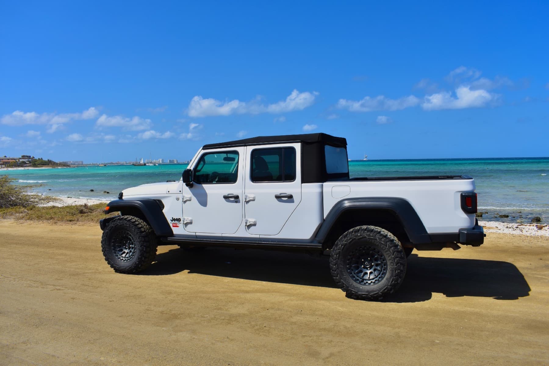 White Jeep Gladiator on a beach road