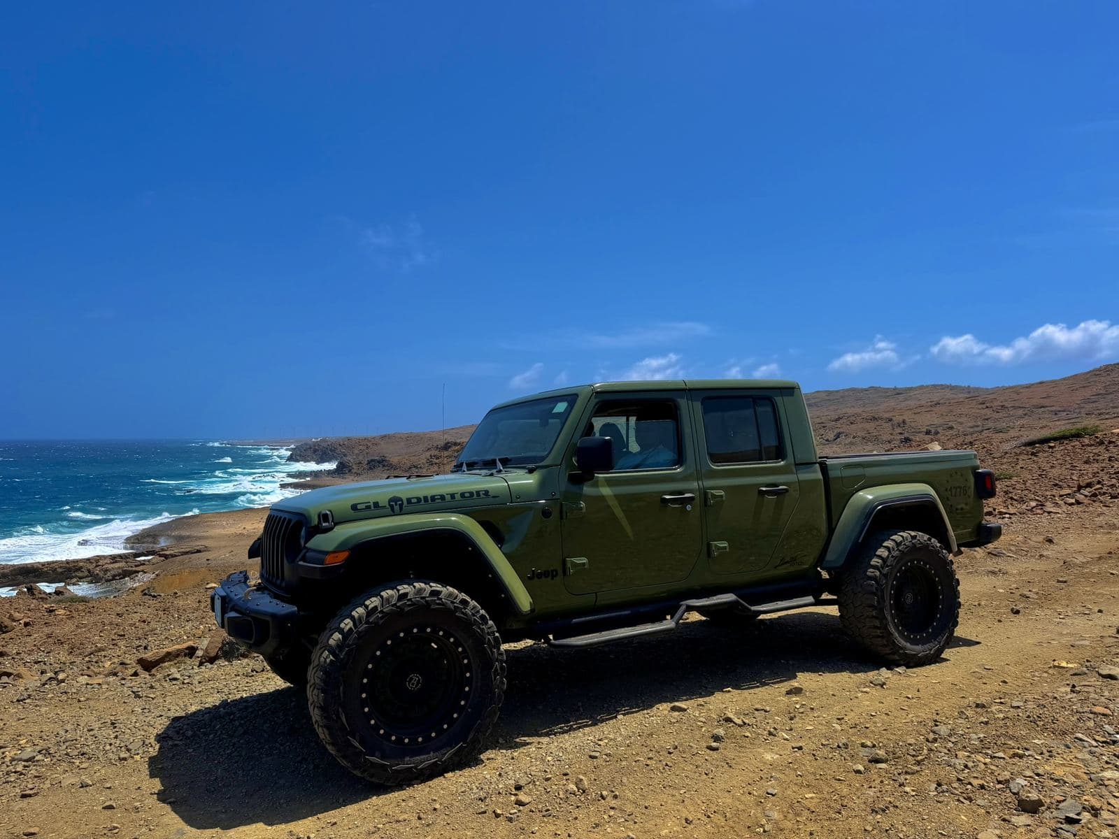 Green Jeep Gladiator on the north coast cliffs